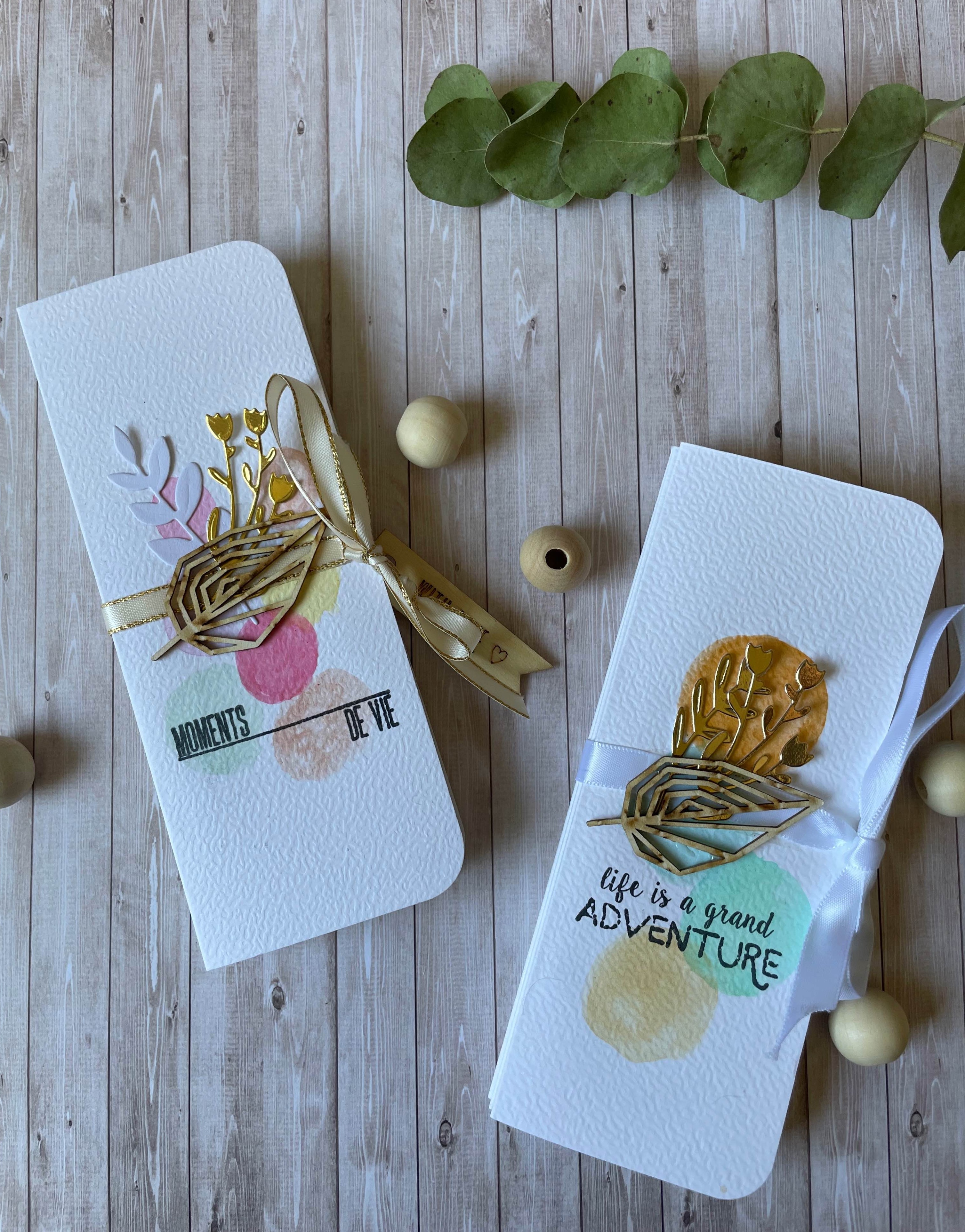 Mini-album de scrapbooking ouvert sur une table, entouré de papiers à motifs