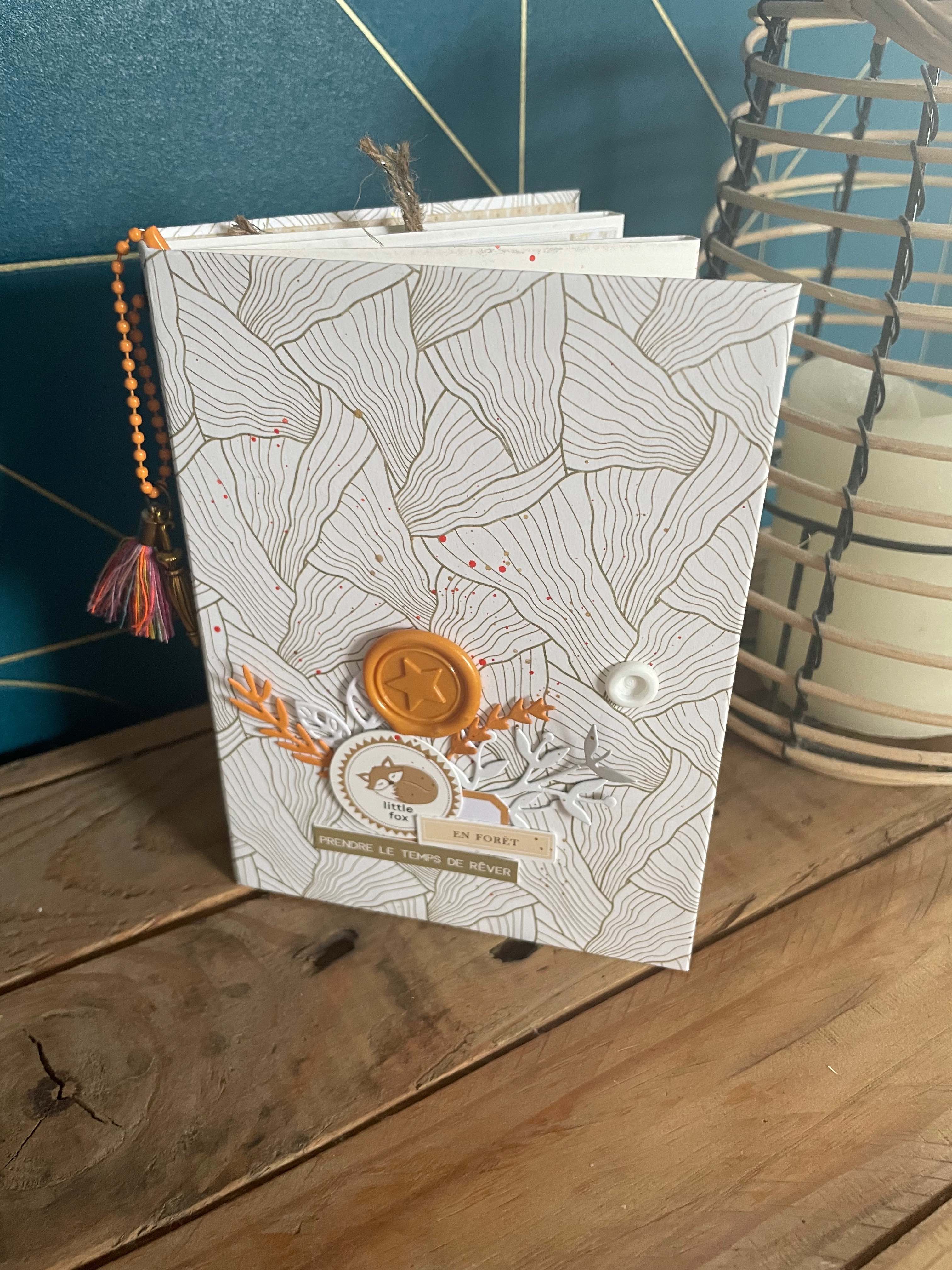 Livre d'or de mariage décoré à la main, ouvert sur une page remplie par les invités